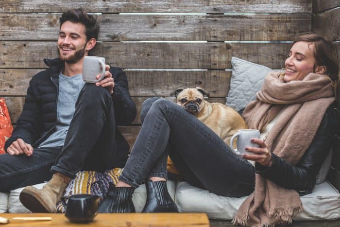 Pug sitting on the lady's lap