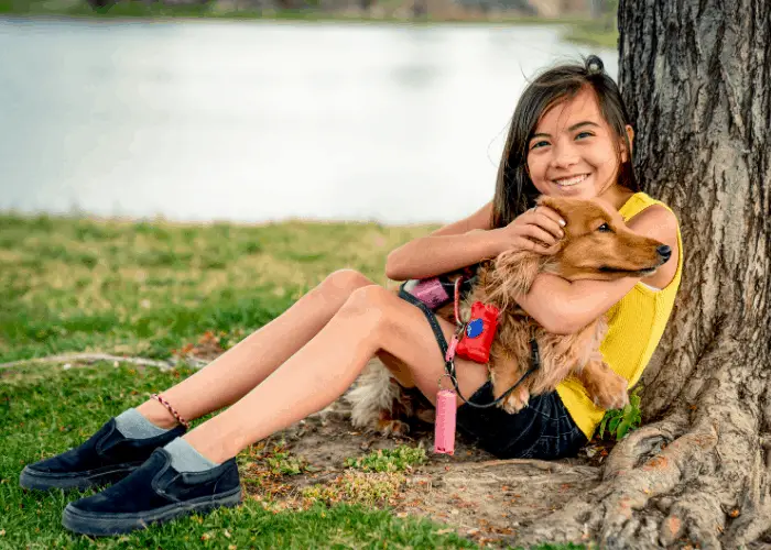 dachsund being hugged by a girl