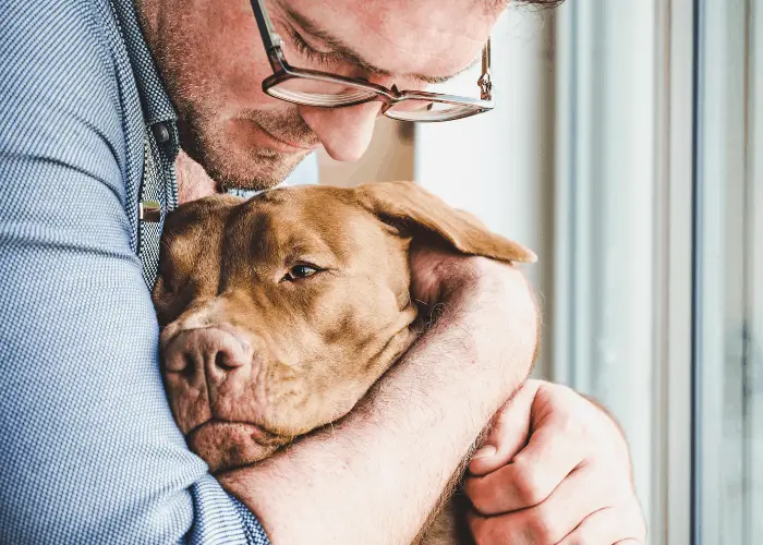 man hugging his dog