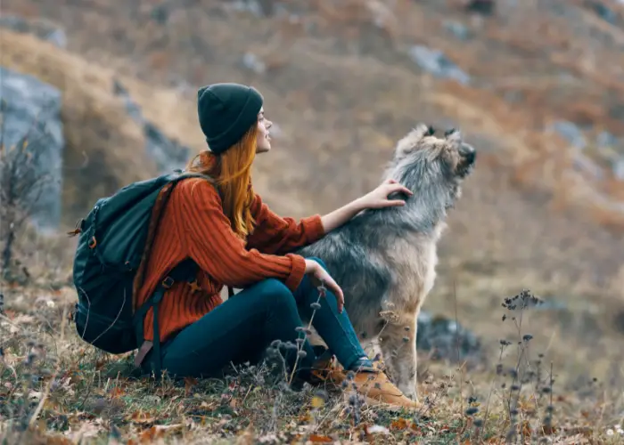 woman and its dog enjoying scenic mountain view